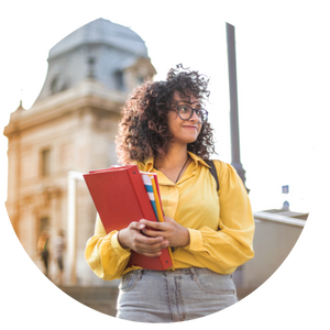student in yellow shirt holding books on college campus