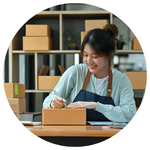 person addressing boxes while wearing apron 