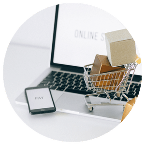small shopping cart on a laptop next to a cell phone